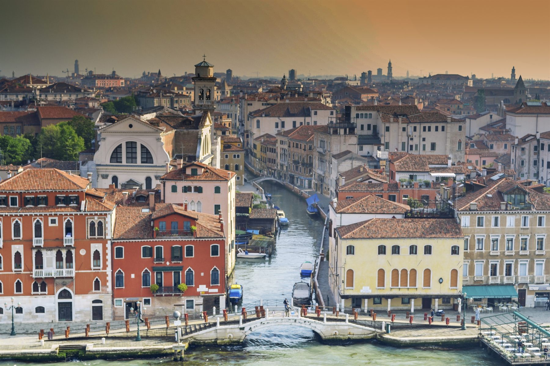 Rooftops, bell towers and a canal in Venice, Italy, in warm evening light