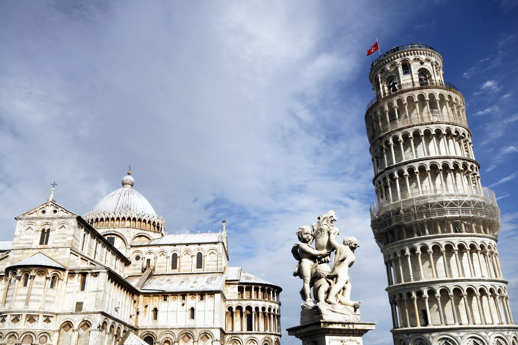 The Leaning Tower of Pisa beside the cathedral dome and a marble statue, Tuscany