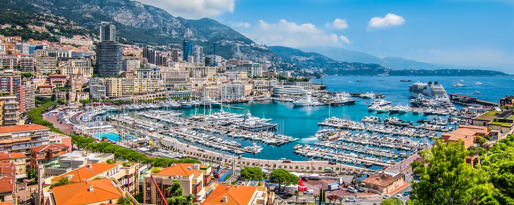 Yachts filling the harbor of Monte Carlo, Monaco, below mountains on the French Riviera
